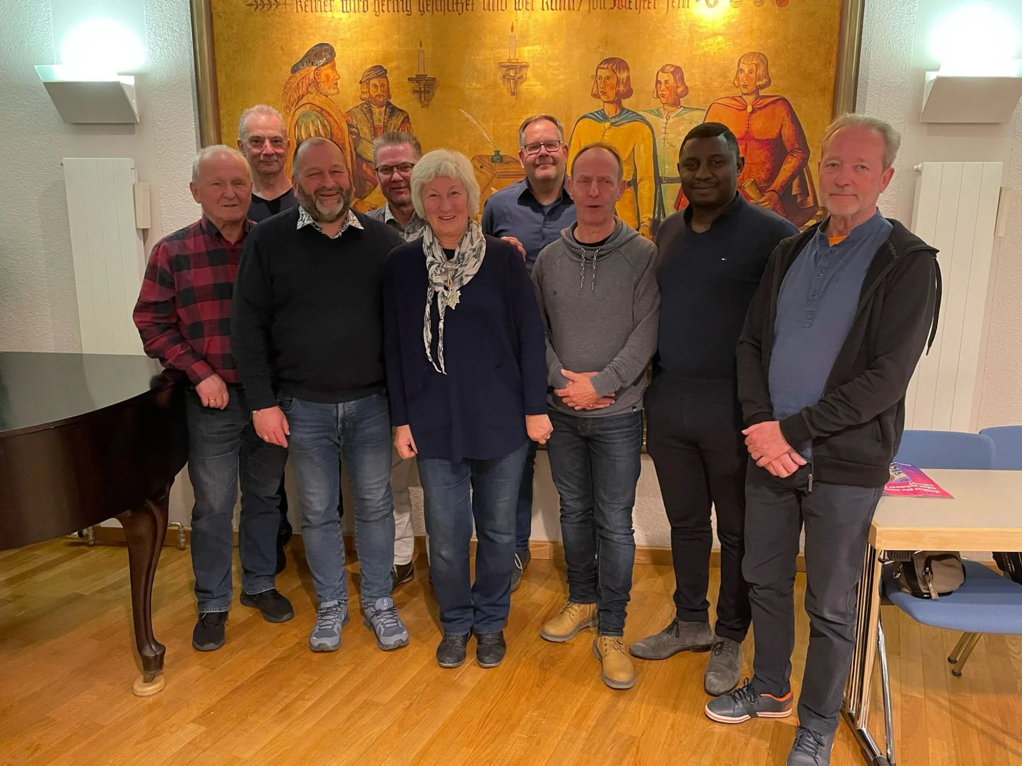 Gruppenfoto des Vorstands des SV Handwerk Cottbus vor einem historischen Wandgemälde